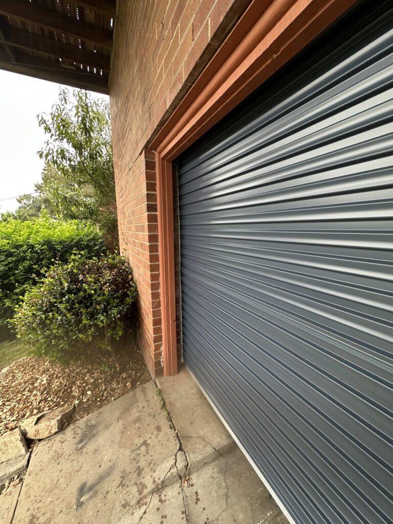 Close-up of a garage door and greenery.