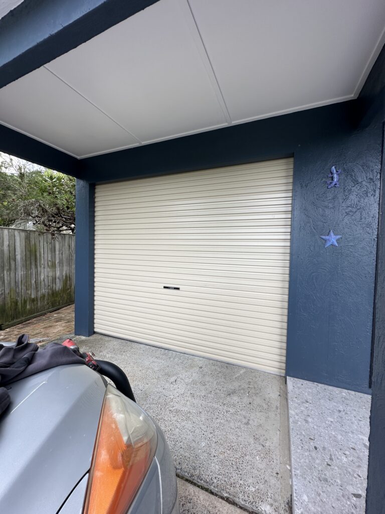 Garage entrance with vehicle parked nearby.