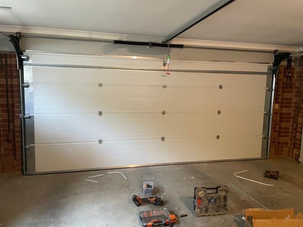 White garage door with tools on the floor