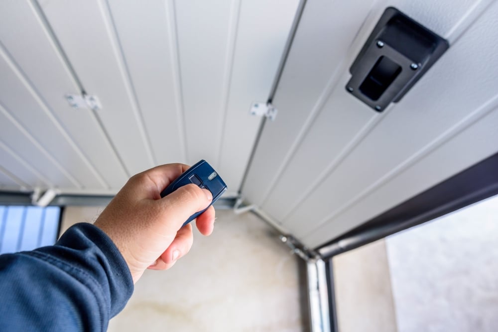Hand using remote to open garage door
