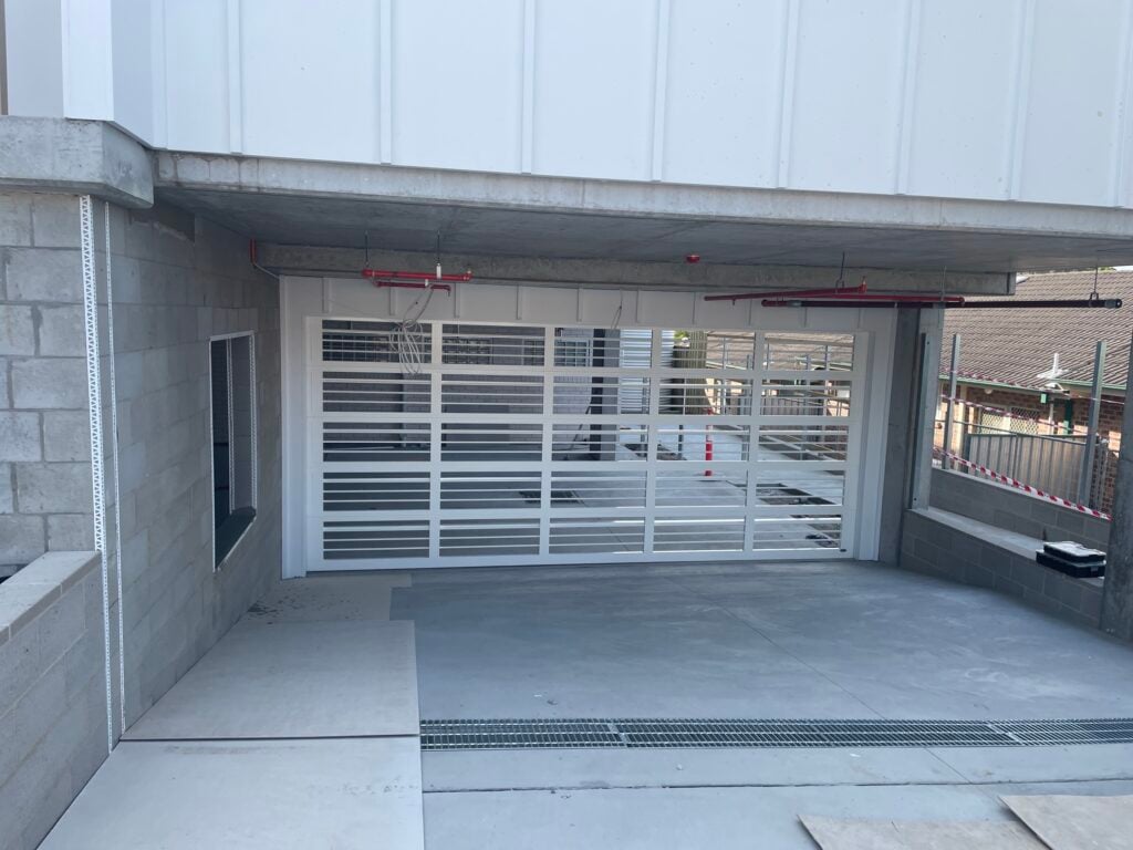 White garage door with concrete surroundings.