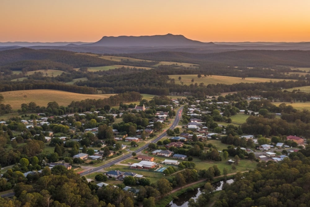 Aerial view of rural town with mountains at sunset