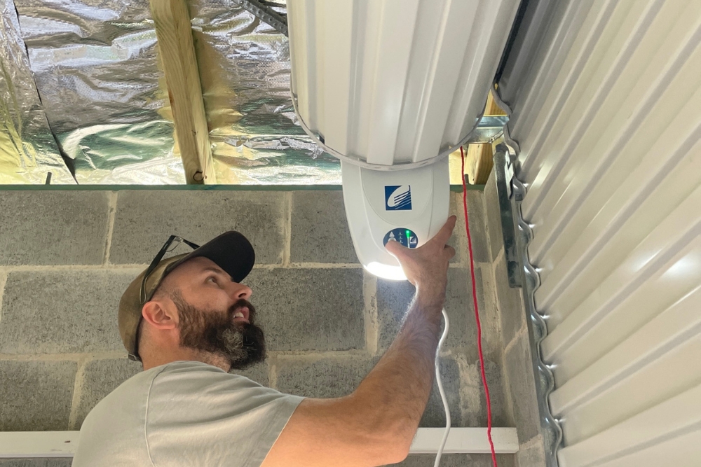 Man adjusting ceiling-mounted heater in shed
