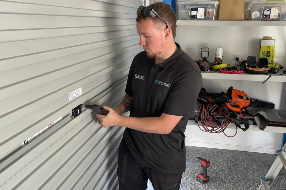 Technician installing garage door motor bracket