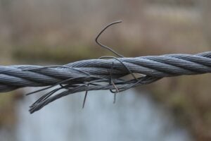 Frayed steel cable with protruding broken wires