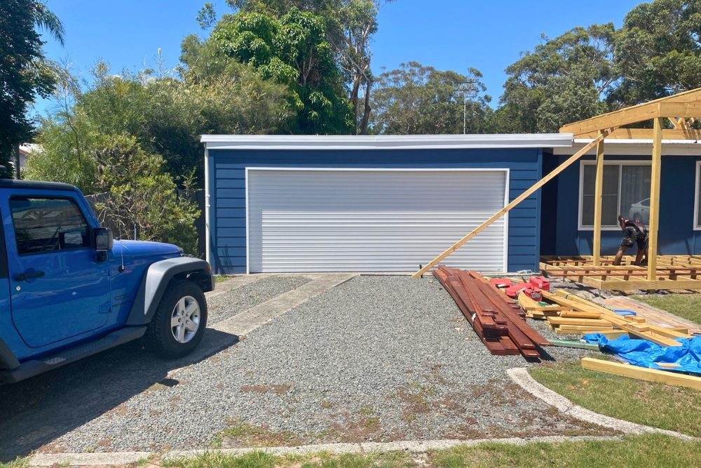 Blue house with roller garage and construction underway